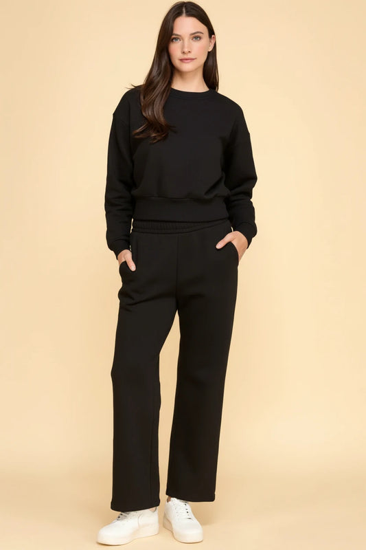 Women modeling a black long-sleeve sweatshirt with matching straight-leg lounge pants and side pockets.