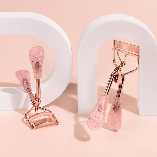 Amorus USA flat handle eyelash curler in rose gold with pink grip. Sold at Lily's Fashion Boutique.