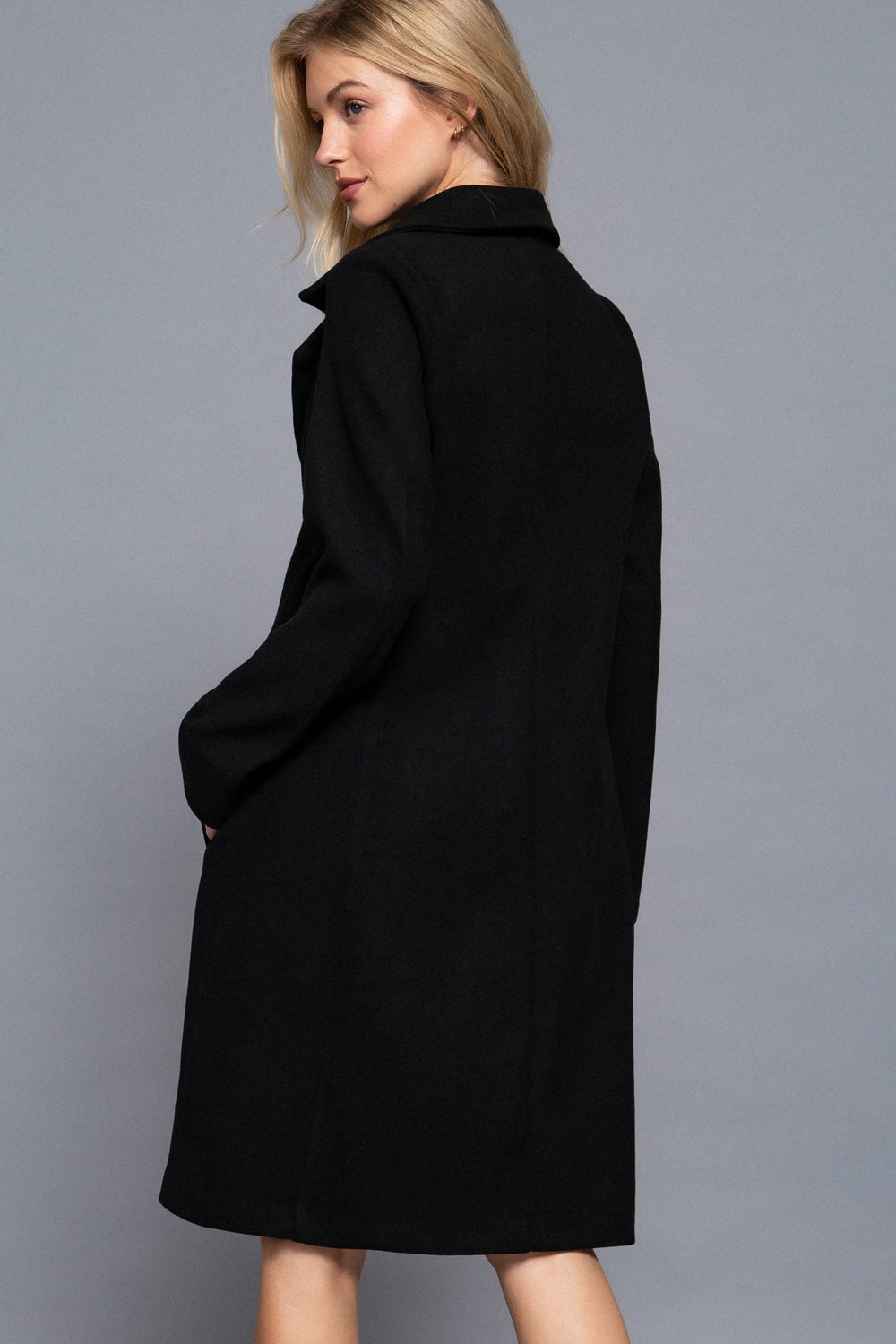 side and back view of the Amelia black a-line coat showing its long sleeves structured silhouette and smooth felt fabric.