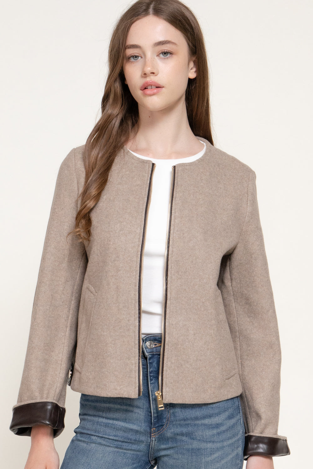 model wearing the beige jacket with a white top and jeans