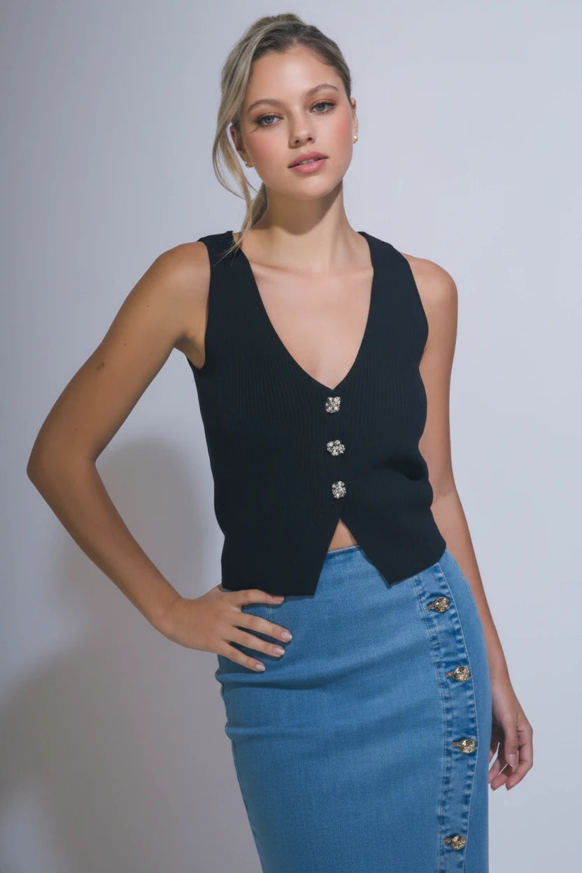 Black sleeveless vest top with a deep v-neckline and statement gold button details. Trendy fitted vest styled with a light denim midi skirt for a chic look.